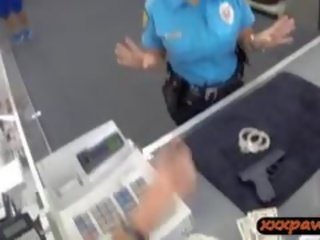 Senhora polícia oficial fica pregado em um loja de penhores para ganhar dinheiro